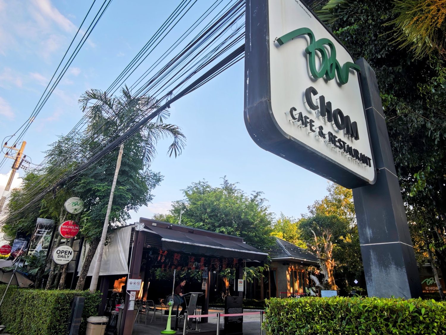 CHOM Cafe 大門口路邊招牌,旁邊掛著 2020-2021 米其林紅牌與 Thai SELECT 標章